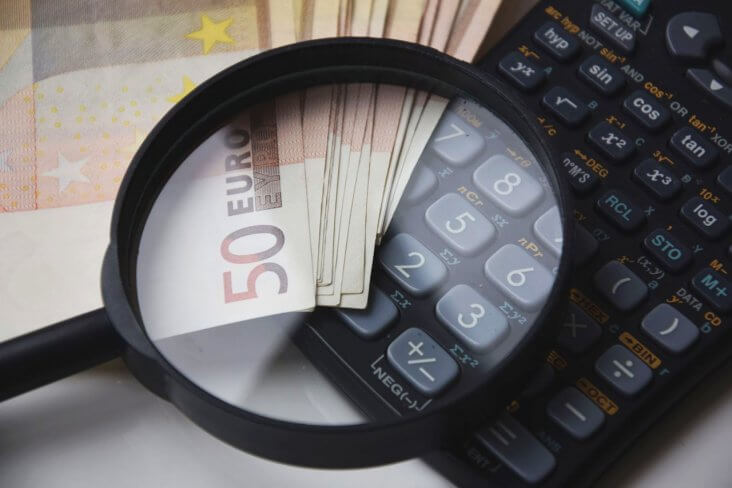 Lupa sobre dinero y calculadora